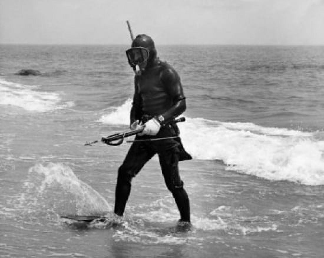 Close-up of a scuba diver holding a harpoon and walking in water on the beach Canvas Art -  (18 x 24)