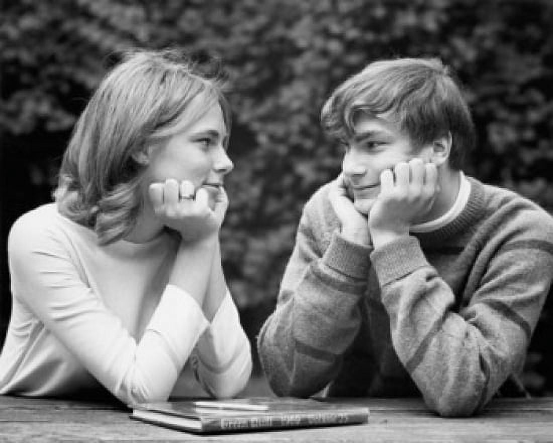 Close-up of a teenage couple sitting at a table and looking at each other Canvas Art - (18 x 24)