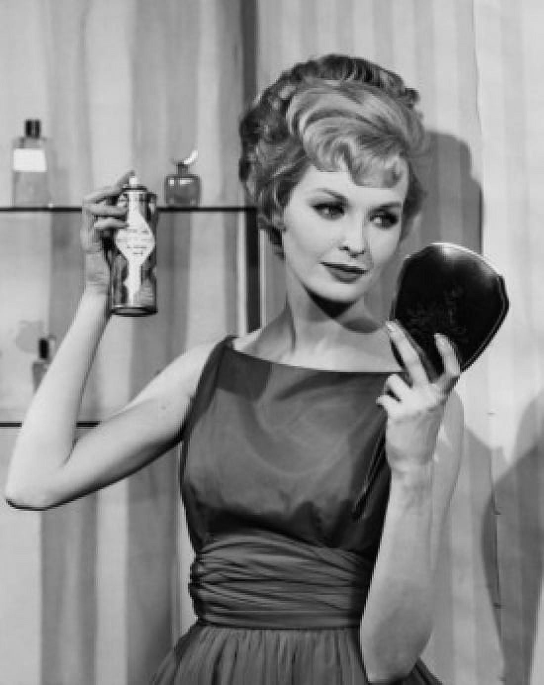 Close-up of a young woman applying hairspray holding a hand mirror Canvas Art - (24 x 36)