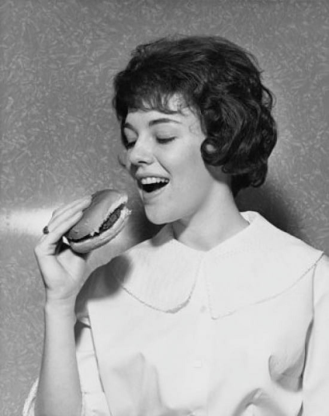 Close-up of a young woman eating a hamburger Canvas Art - (24 x 36)