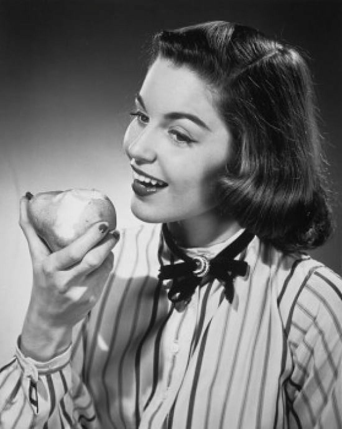 Close-up of a young woman eating a pear Canvas Art - (24 x 36)