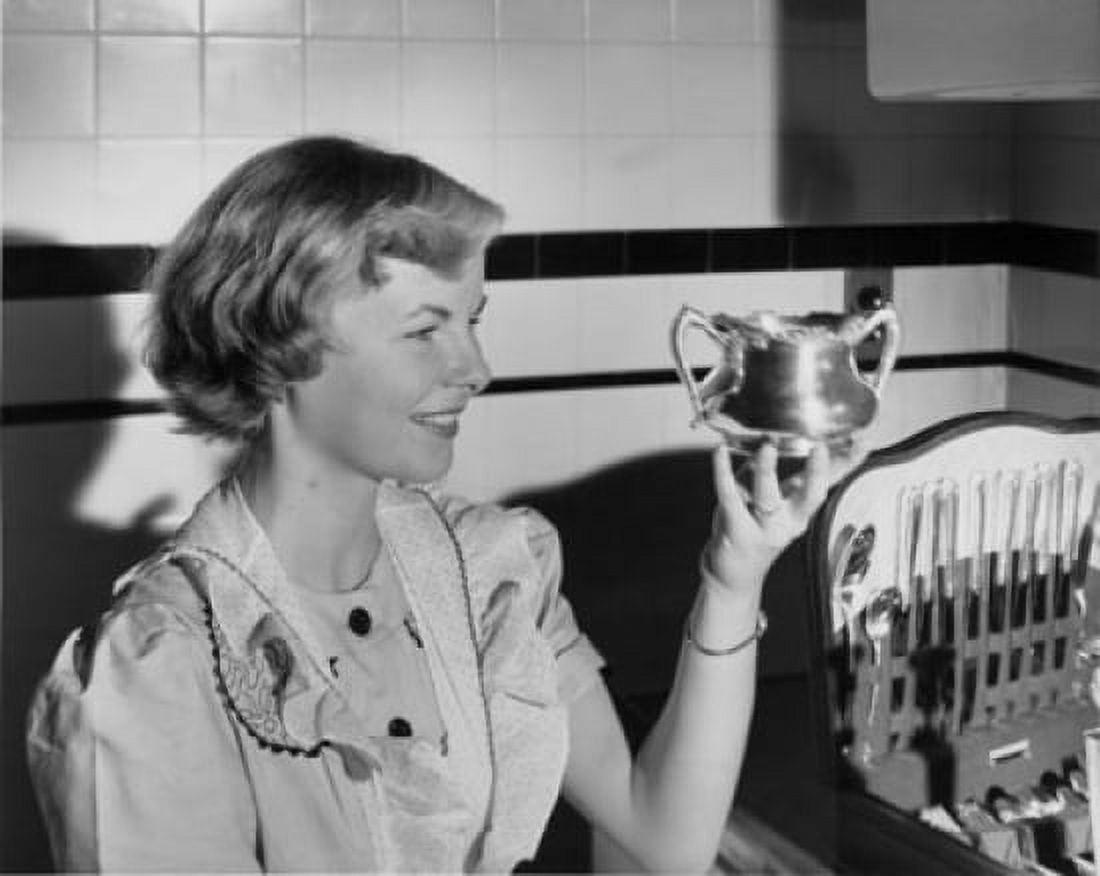 Close-up of a young woman looking at piece of silver Canvas Art - (18 x 24)