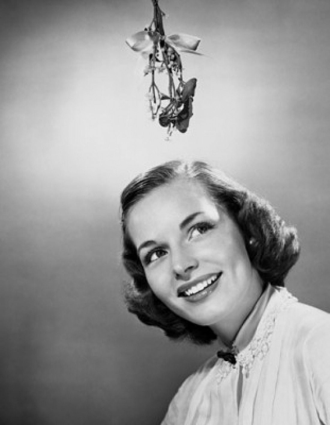 Close-up of a young woman smiling with mistletoe hanging over her head Canvas Art - (18 x 24)