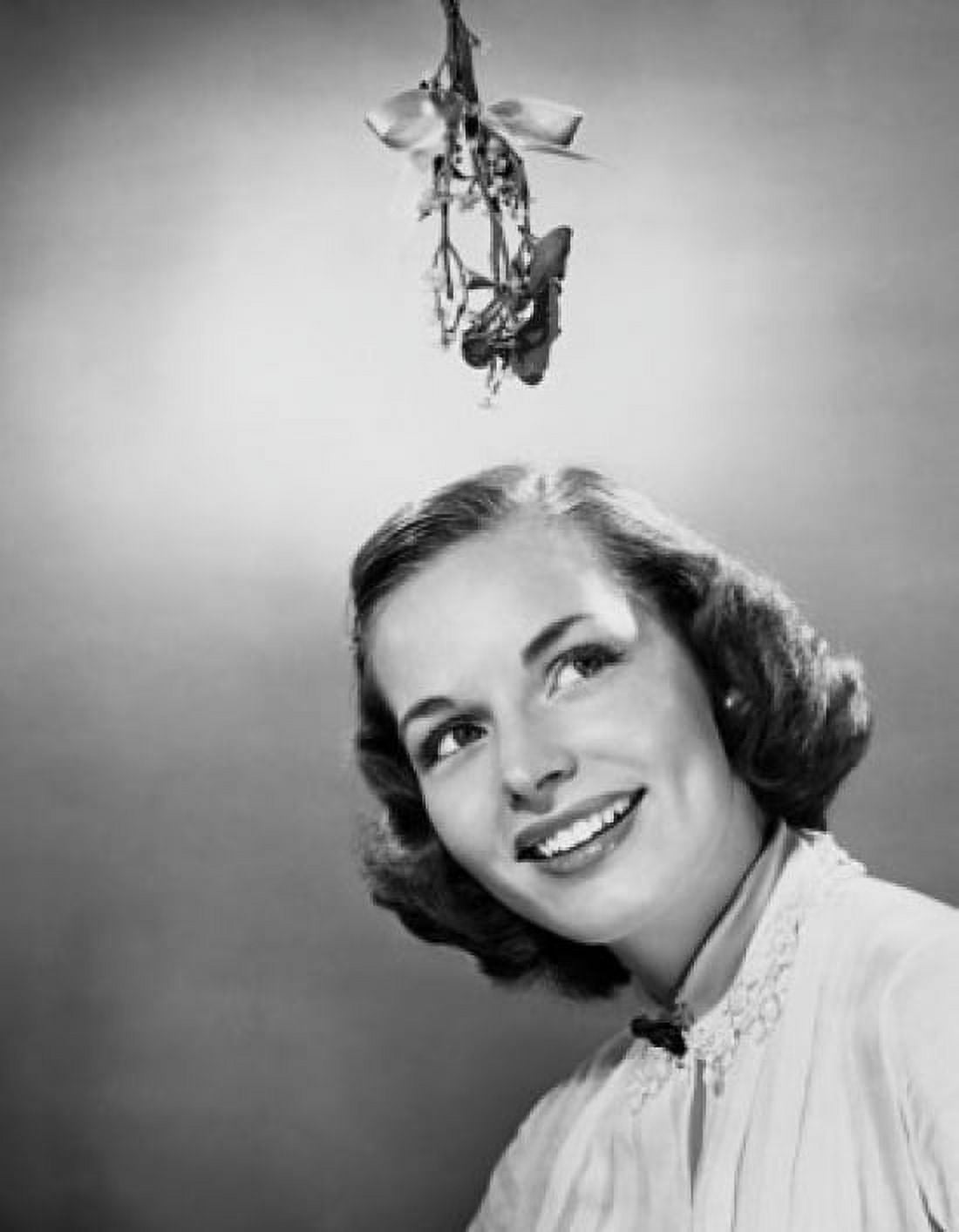 Close-up of a young woman smiling with mistletoe hanging over her head Canvas Art - (24 x 36)