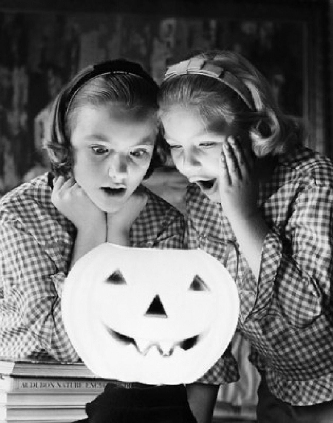 Close-up of two girls looking at an illuminated jack o lantern Canvas Art - (24 x 36)