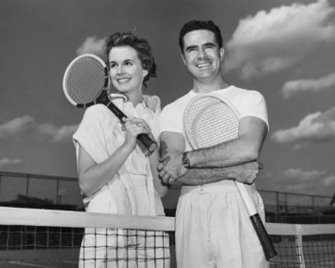 Close-up view of young couple holding tennis rackets and smiling Canvas Art - (24 x 36)