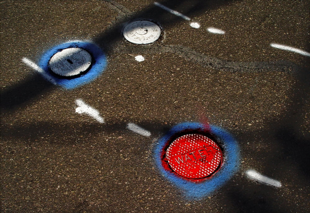 Colorful storm drain covers and white lines on the road Canvas Art - Panoramic Images (36 x 24)