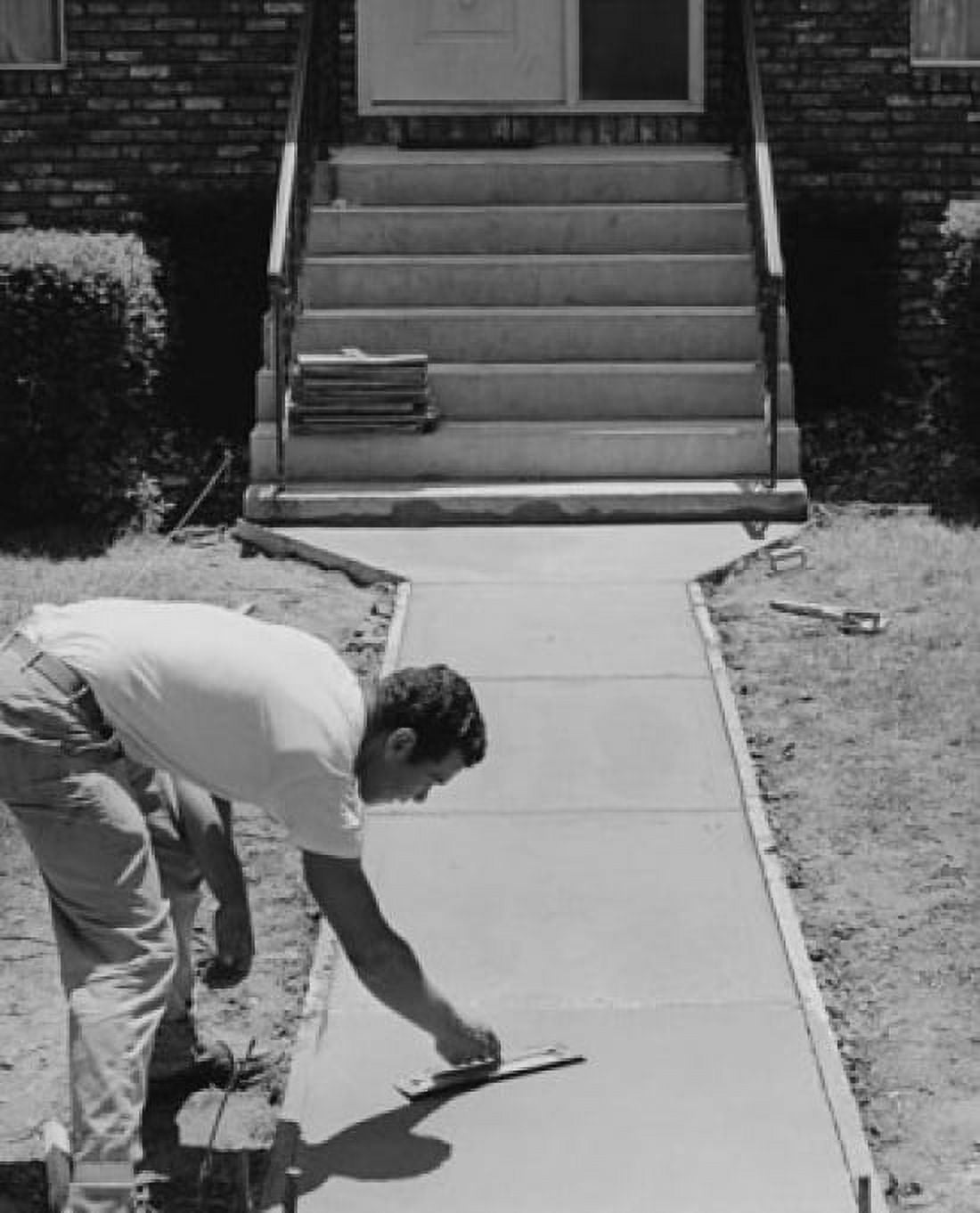 Construction worker smoothing a concrete sidewalk in front of a house Canvas Art - (24 x 36)