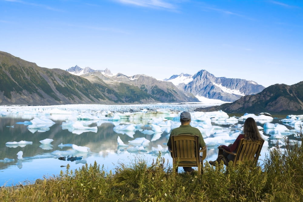 Couple Relaxing Along Bear Glacier Lake With Kenai Mountains In The Background Kenai Peninsula Southcentral Alaska Canvas Art - Michael DeYoung Design Pics (17 x 11)