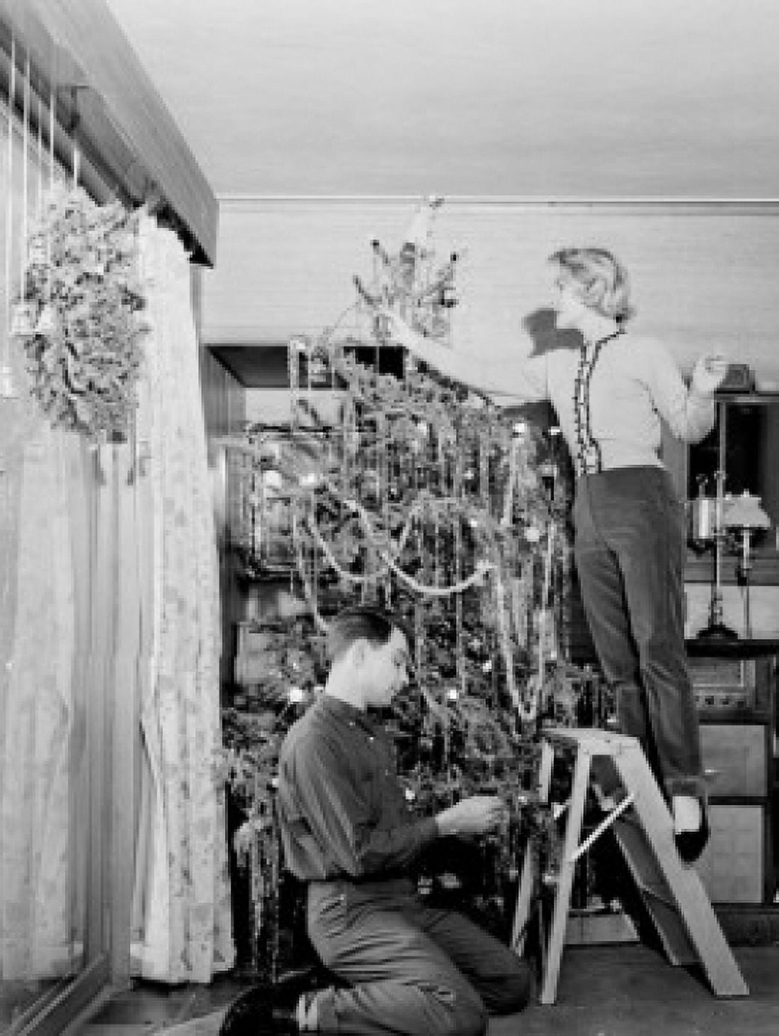 Couple decorating Christmas tree at home Canvas Art - (24 x 36)