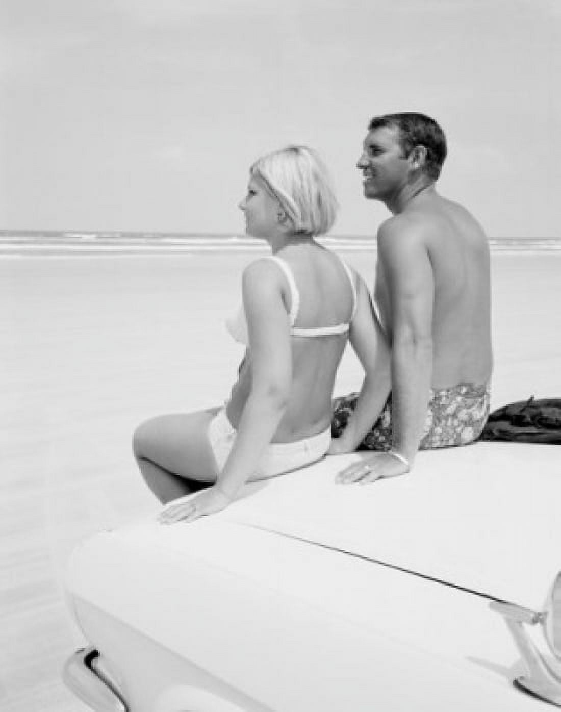 Couple in swimwear sitting on hood of car on beach Canvas Art - (18 x 24)
