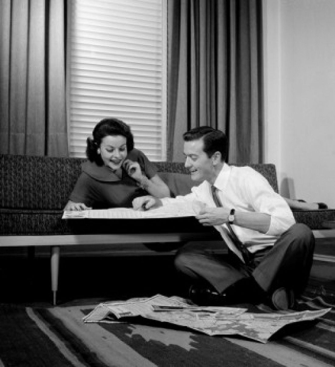 Couple looking at map in living room Canvas Art - (24 x 36)