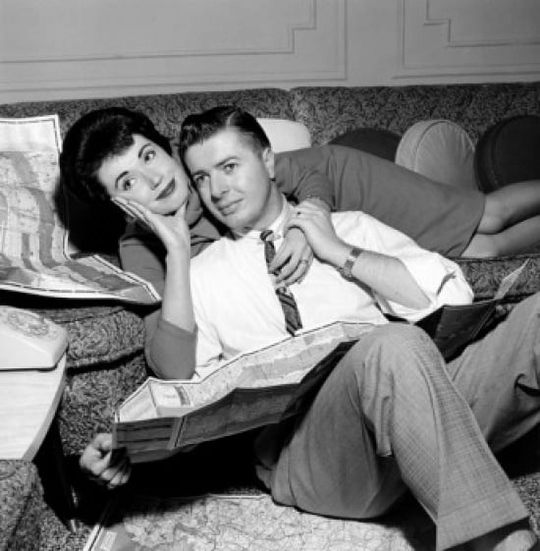 Couple lying on sofa with spread out maps Canvas Art - (18 x 24)