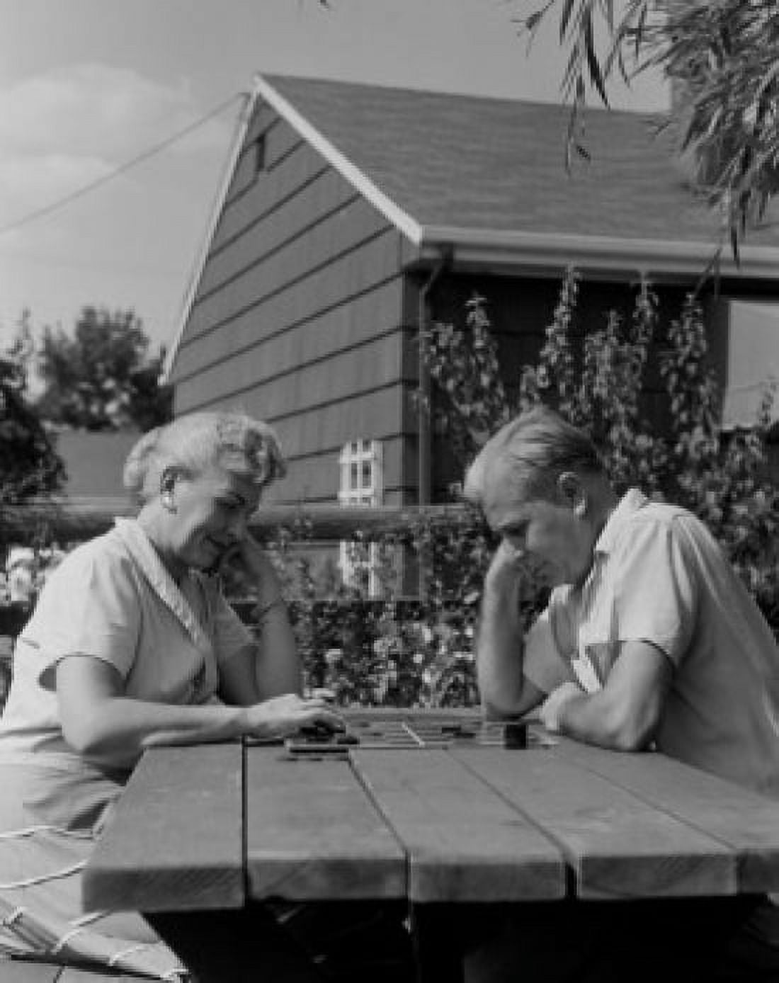 Couple playing draughts at outdoor table Canvas Art - (24 x 36)