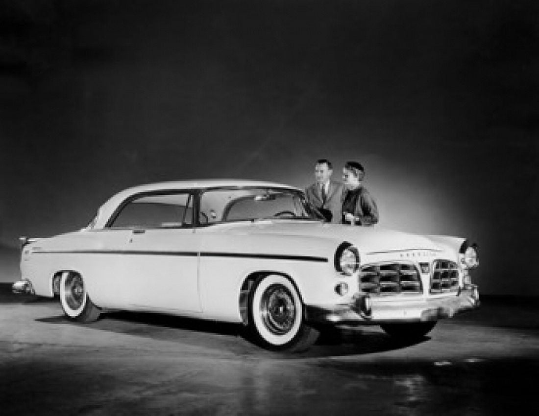 Couple standing near a 1955 Chrysler 300 Canvas Art - (24 x 36)