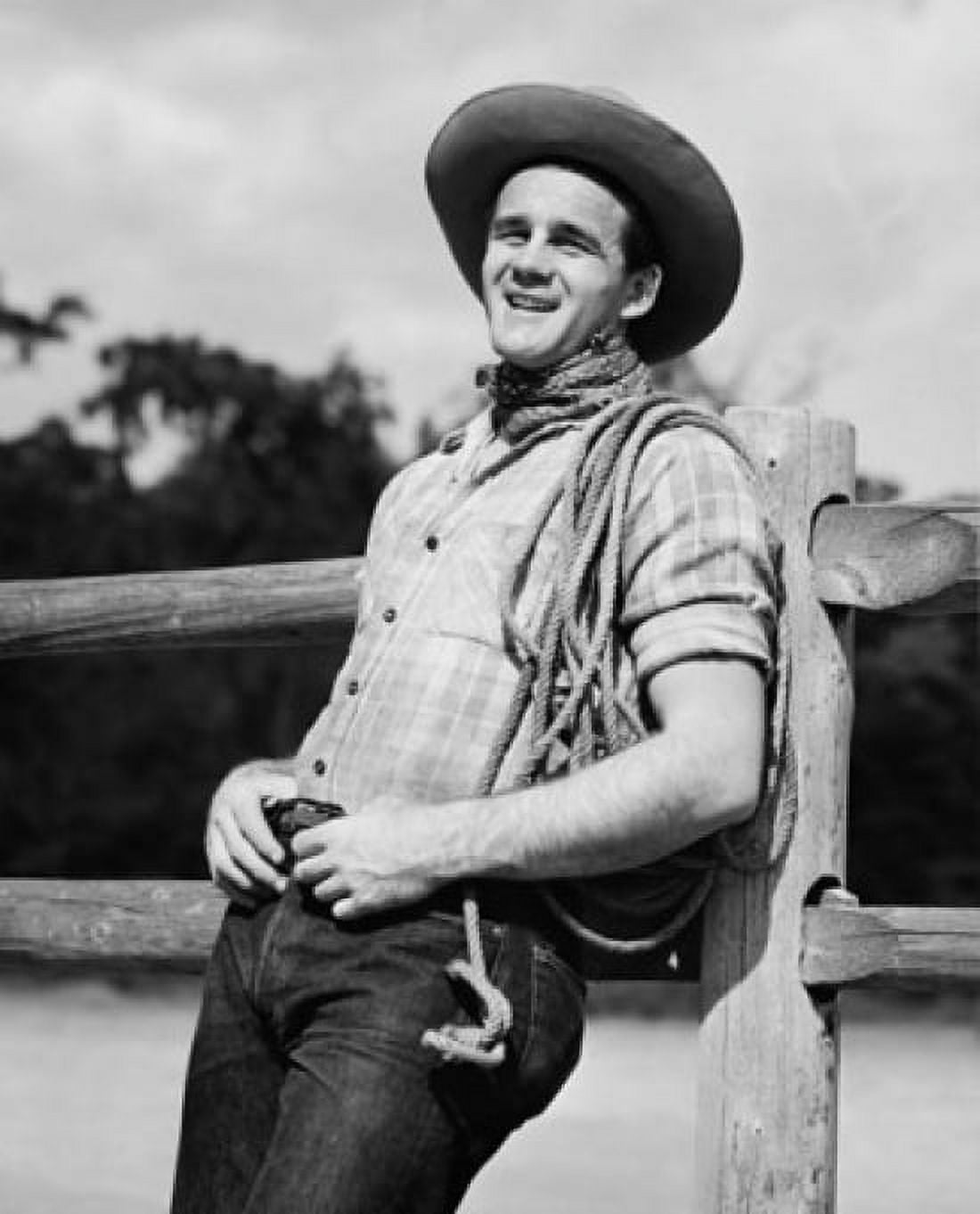 Cowboy with rope smiling and leaning against a fence Canvas Art - (18 x 24)