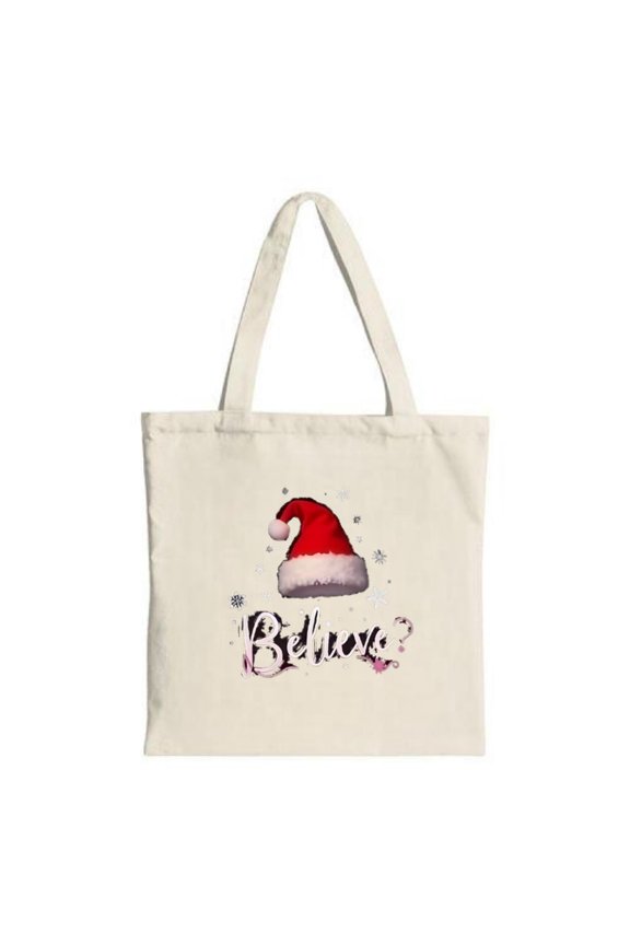 Cream canvas tote bag featuring a red Santa hat with a fluffy brim and snowflakes adorned with the word " Believe " in pink floral font