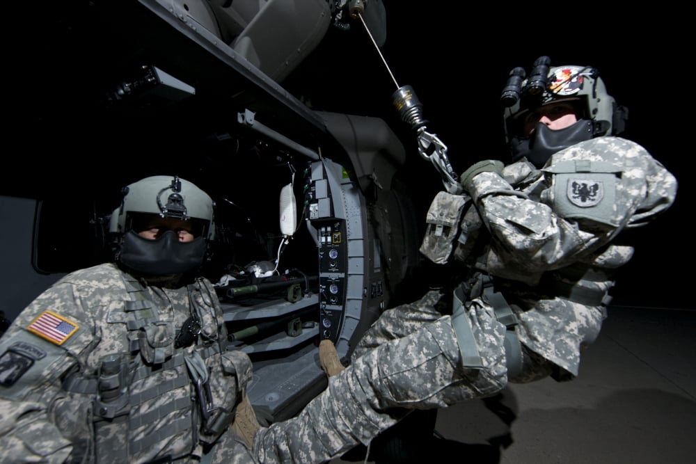 Crew Chief sits in the doorway of a UH-60 Black Hawk while medic sits on the hoist Canvas Art - Terry MooreStocktrek Images (35 x 23)