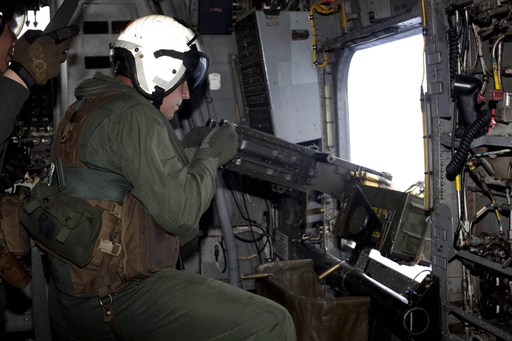 Crew chief fires an M2 50-caliber heavy machine gun from a CH-53E Super Stallion Canvas Art - Stocktrek Images (35 x 23)