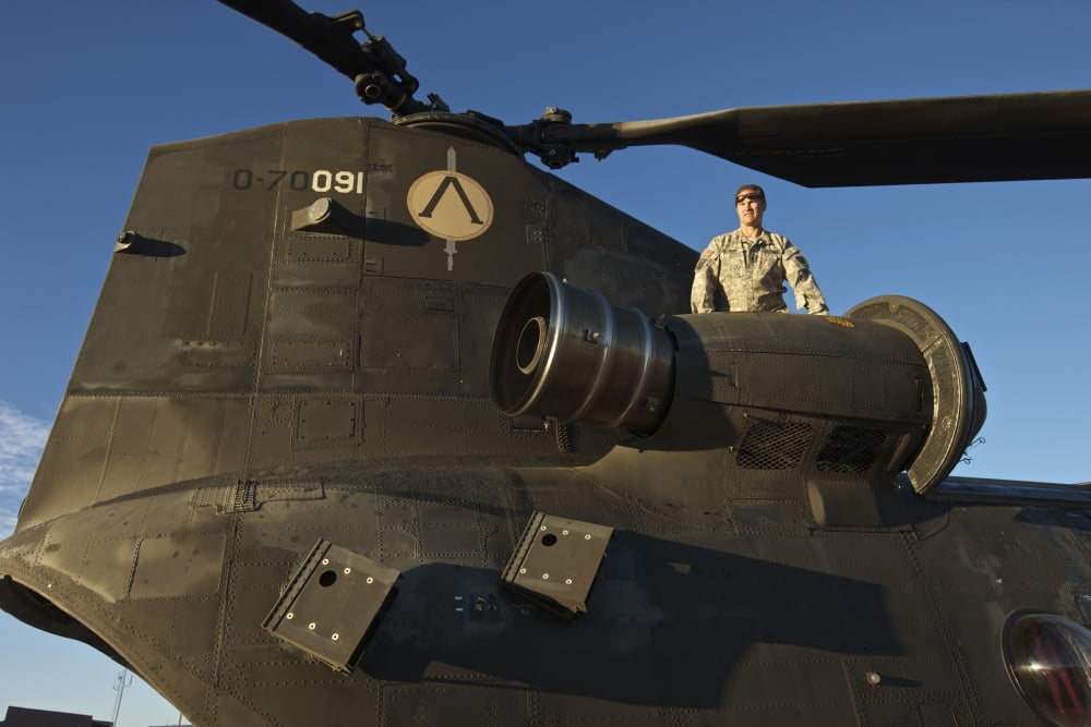 Crew chief inspects the engine of a CH-47 Chinook Canvas Art - Terry MooreStocktrek Images (18 x 12)