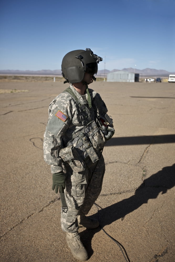 Crew chief of a CH-47 Chinook stands outside the aircraft Canvas Art - Terry MooreStocktrek Images (12 x 18)