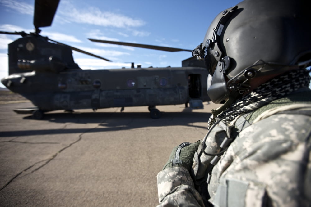 Crew chief of a CH-47 Chinook stands outside the aircraft Canvas Art - Terry MooreStocktrek Images (18 x 12)