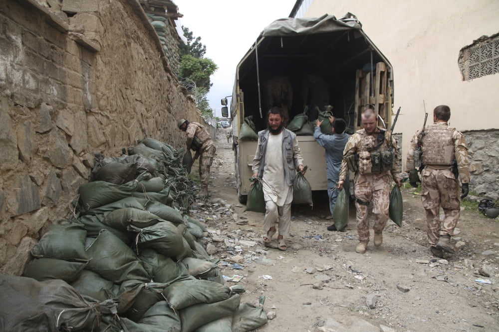Czech soldiers and Afghan Uniform Police officers unload sandbags from a truck Canvas Art - Stocktrek Images (34 x 23)