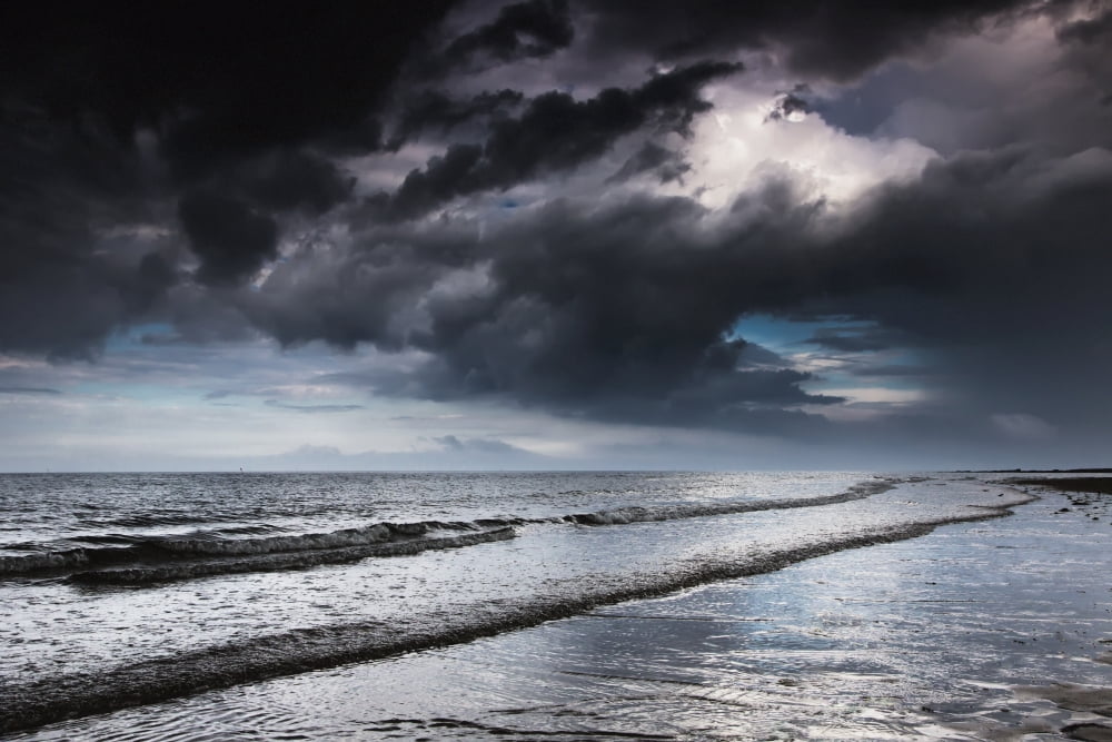Dark storm clouds over the ocean with waves rolling into the shoreDruridge bay northumberland england Canvas Art - John Short Design Pics (19 x 12)