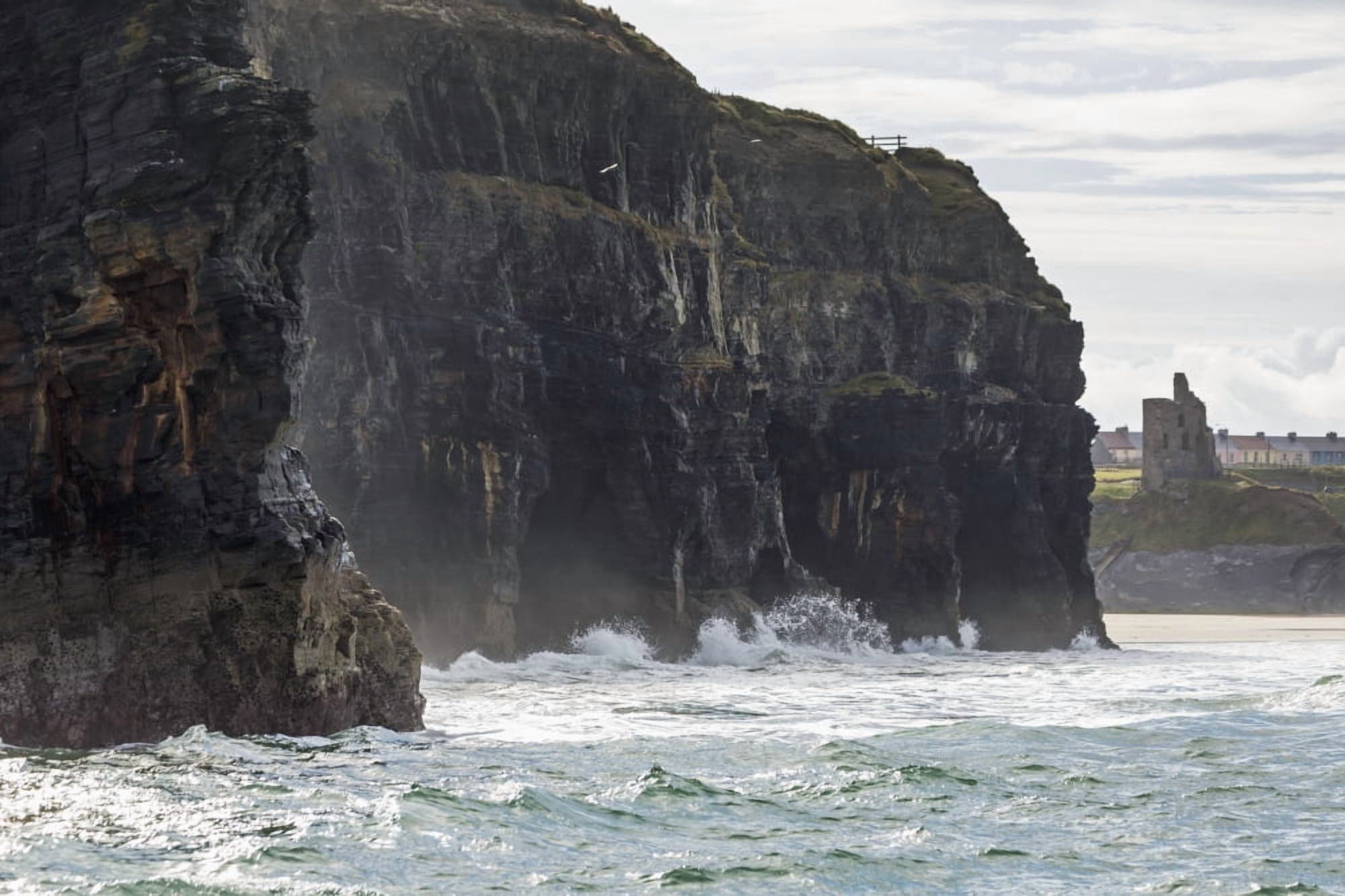 Dark straight cliffs with waves crashing into the rock with ruined castle turret in background Ballybunion County Kerry Ireland Canvas Art - Michael Interisano Design Pics (19 x 12)