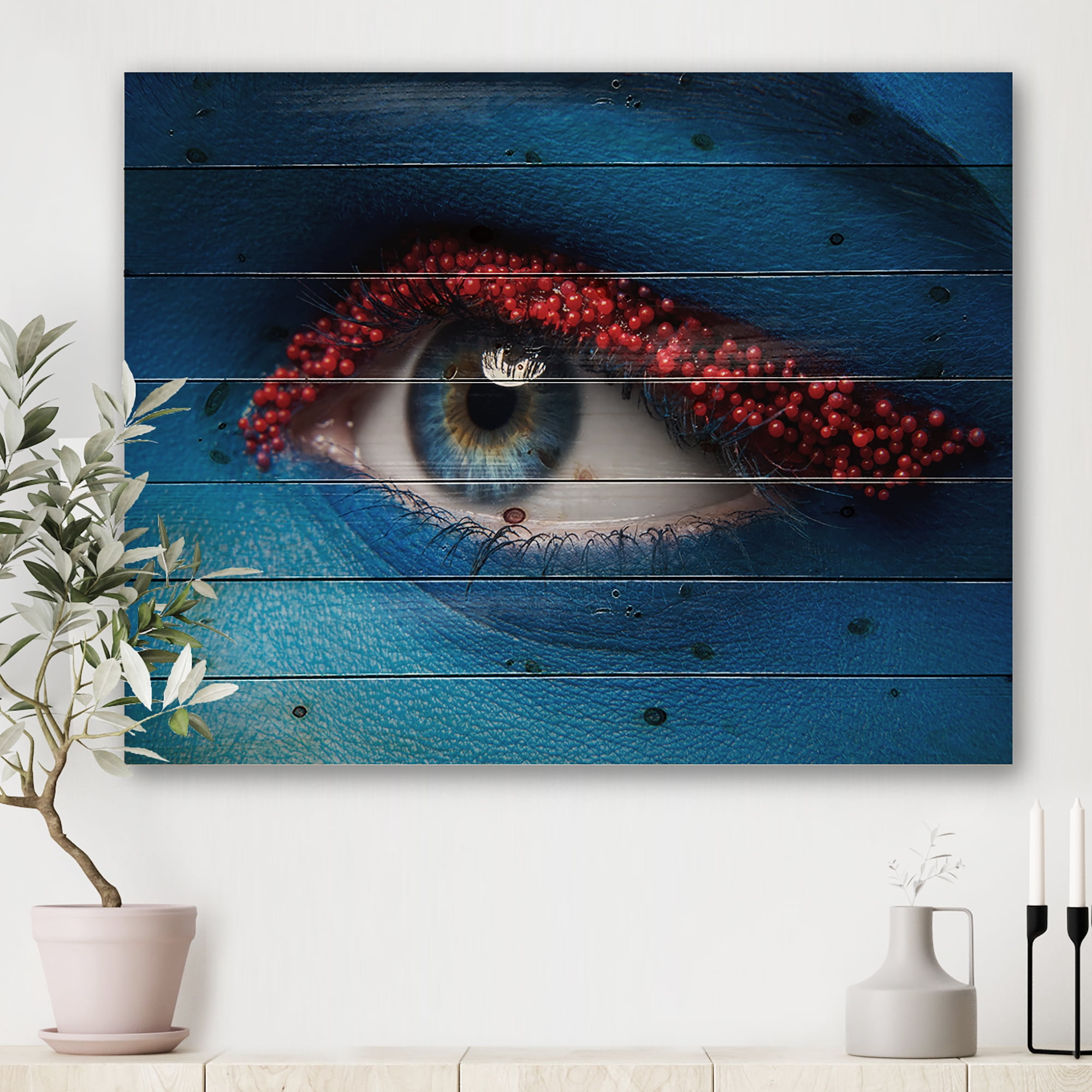 Designart 'Woman Eye With Blue Paint On Face & Red Balls' Modern Print on Natural Pine Wood