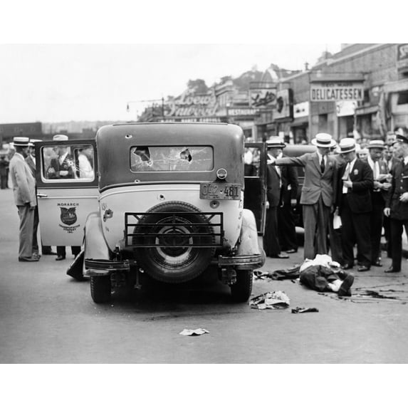 Detectives Seek To Identify The Body Of A Slain Gunman Lying In The Street Beside A Bullet Ridden Taxi. The Gangsters