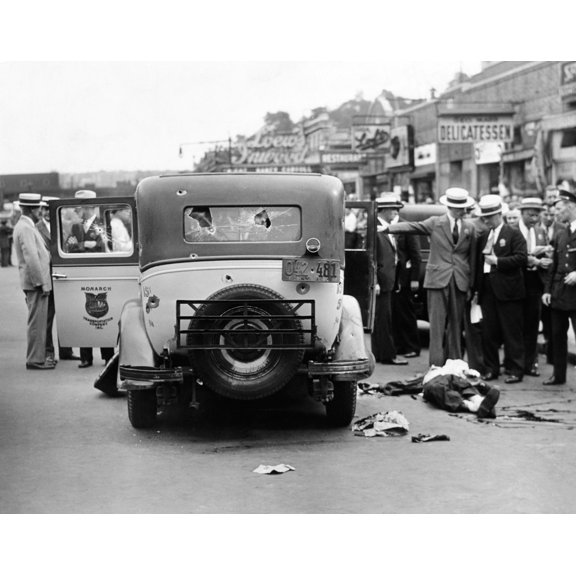 Detectives Seek To Identify The Body Of A Slain Gunman Lying In The Street Beside A Bullet Ridden Taxi. The Gangsters
