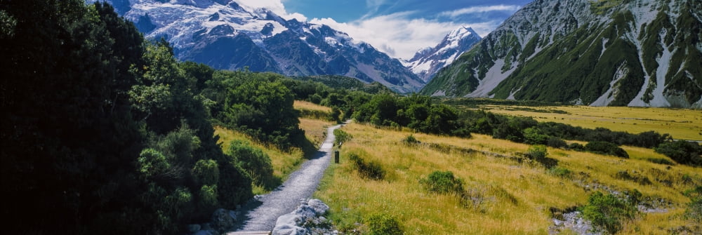 Dirt road passing through a landscape with a mountain range in the background Mt Cook National Park Aoraki Mount Cook Village South Island New Zealand Canvas Art - Panoramic Images (27 x 9)
