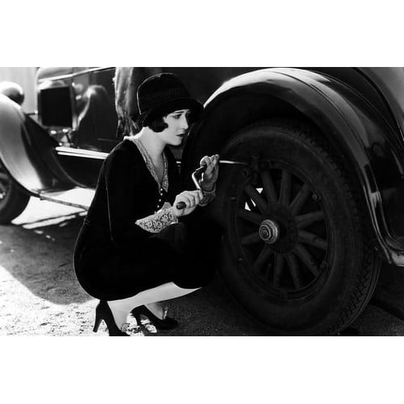 Dorothy Sebastian changing tire on vintage car 24x36 Poster
