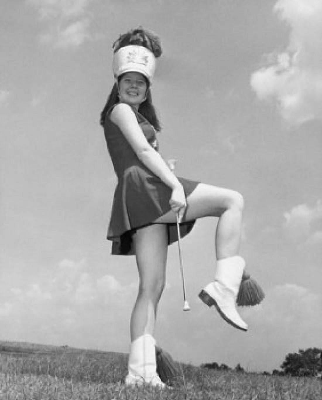 Drum majorette performing with a twirling baton in a field and smiling Canvas Art - (24 x 36)
