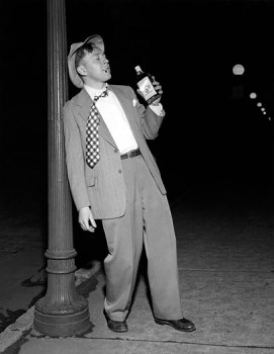 Drunk mid adult man leaning against a lamppost holding a bottle of alcohol Canvas Art - (18 x 24)