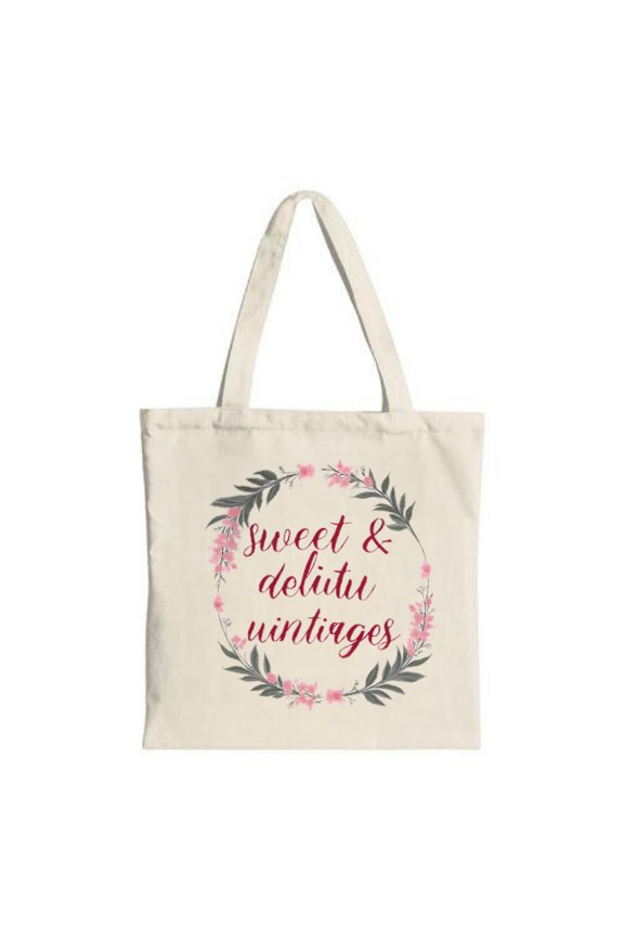 Elegant cream tote bag with a pink and gray floral wreath featuring ' sweet & deltu vintages ' in flowing script Perfect for shopping