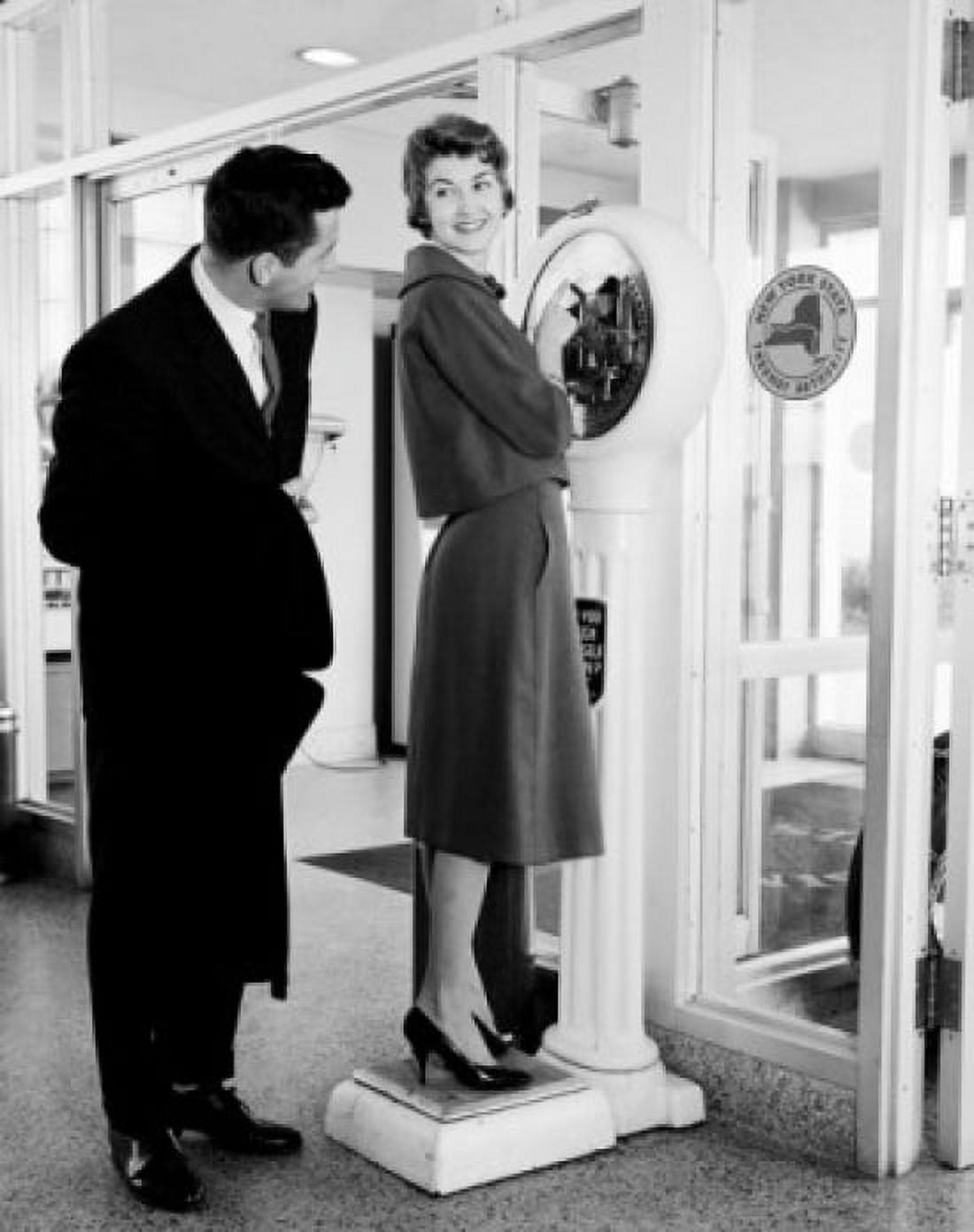Elegant woman on weight scale with man peeking Canvas Art - (18 x 24)