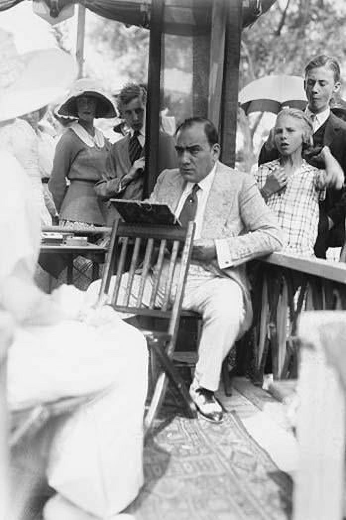 Enrico Caruso Leans back on chair holding a Board with Music; he is surrounded by adoring Crowds Poster Print by unknown (24 x 36) - image 1 of 1