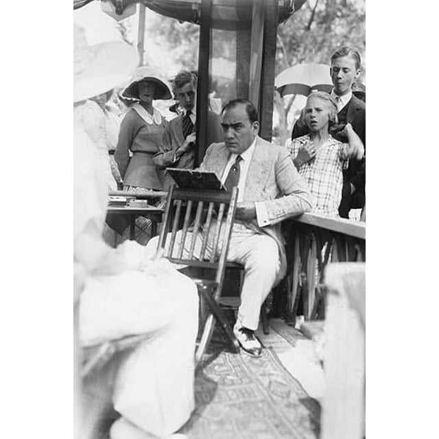 Enrico Caruso Leans back on chair holding a Board with Music; he is surrounded by adoring Crowds Poster Print by unknown (24 x 36)