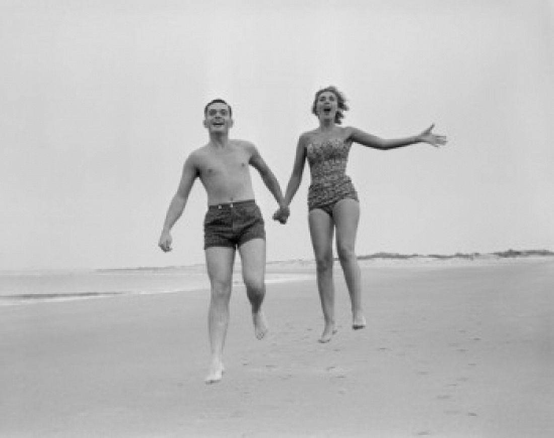 Exhilarated young couple running on sandy beach Canvas Art - (18 x 24)