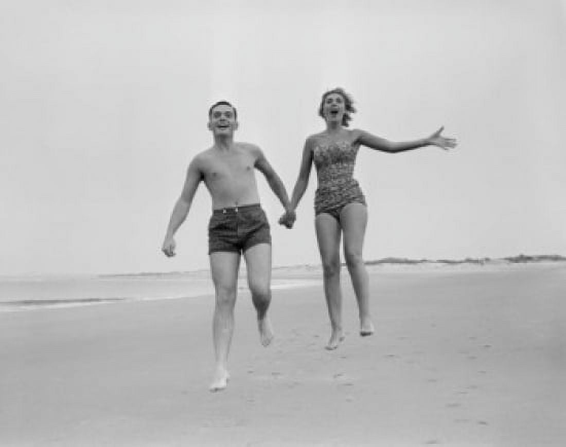 Exhilarated young couple running on sandy beach Canvas Art - (24 x 36)