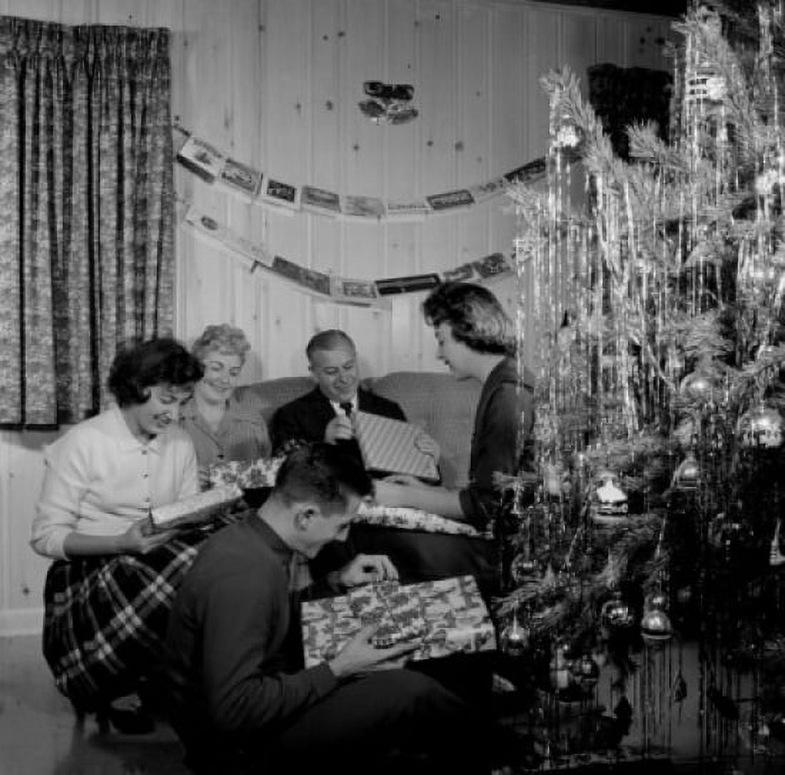 Family opening gifts by Christmas tree in living room Canvas Art - (24 x 36)