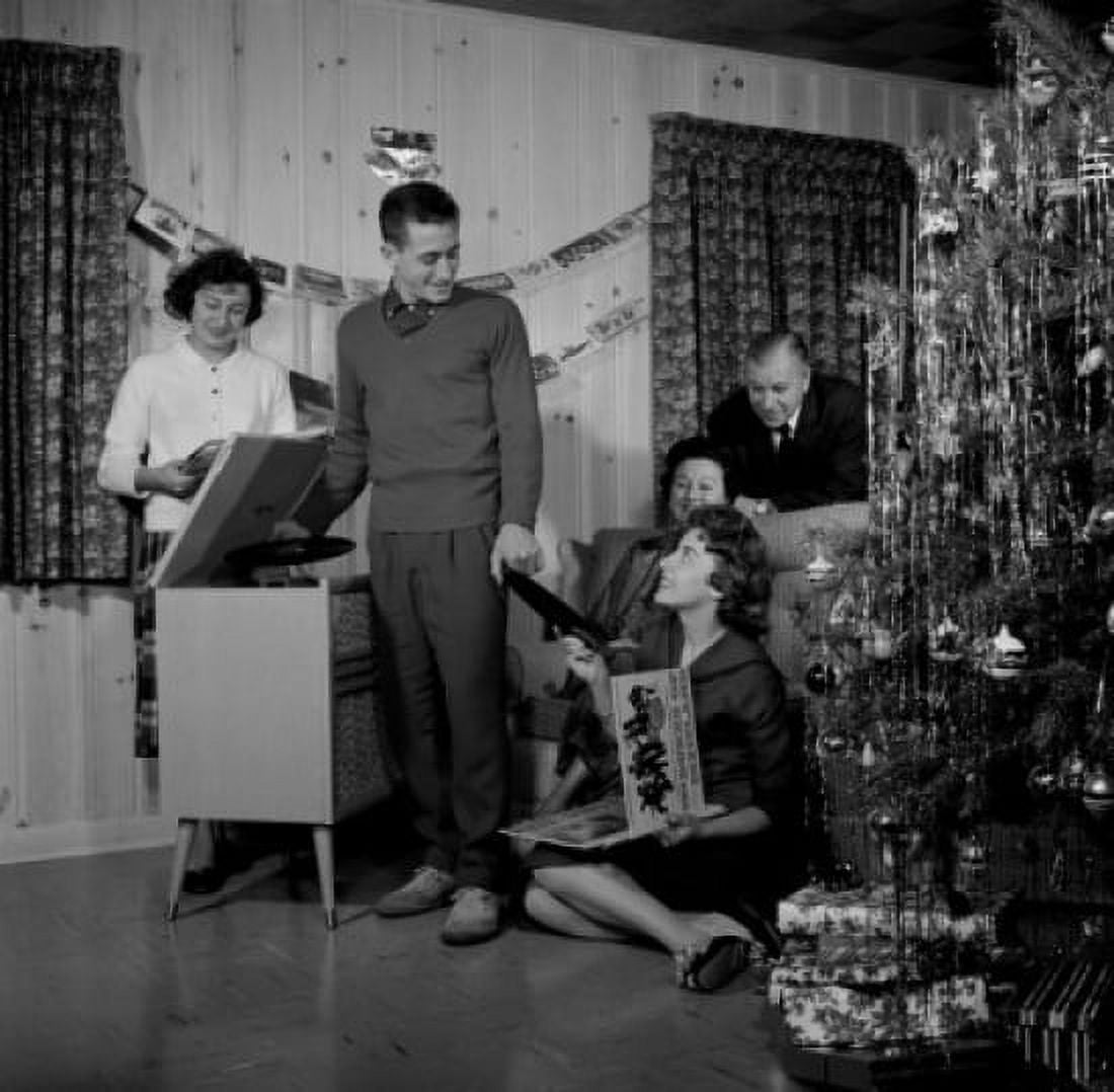 Family playing records on record player by Christmas tree Canvas Art - (24 x 36)