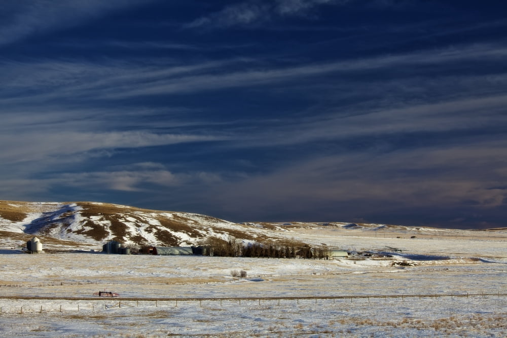Farm At Bottom Of Hill In Winter Badlands Of Alberta Canvas Art - Roberta Murray Design Pics (34 x 22)