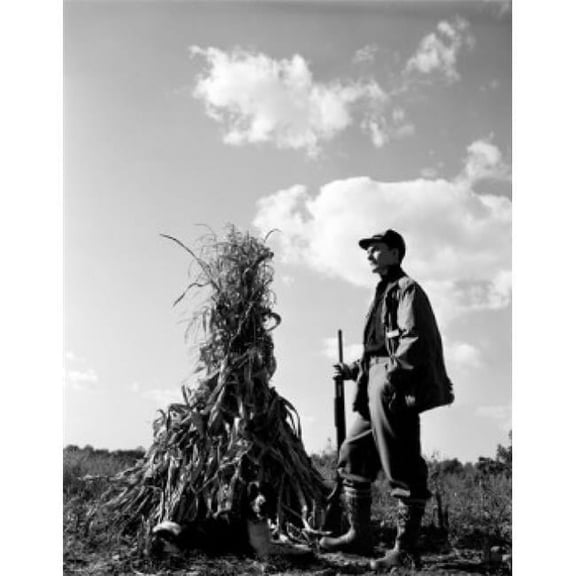 Farmer Standing on Field & Holding Gun Poster Print - 18 x 24 in.