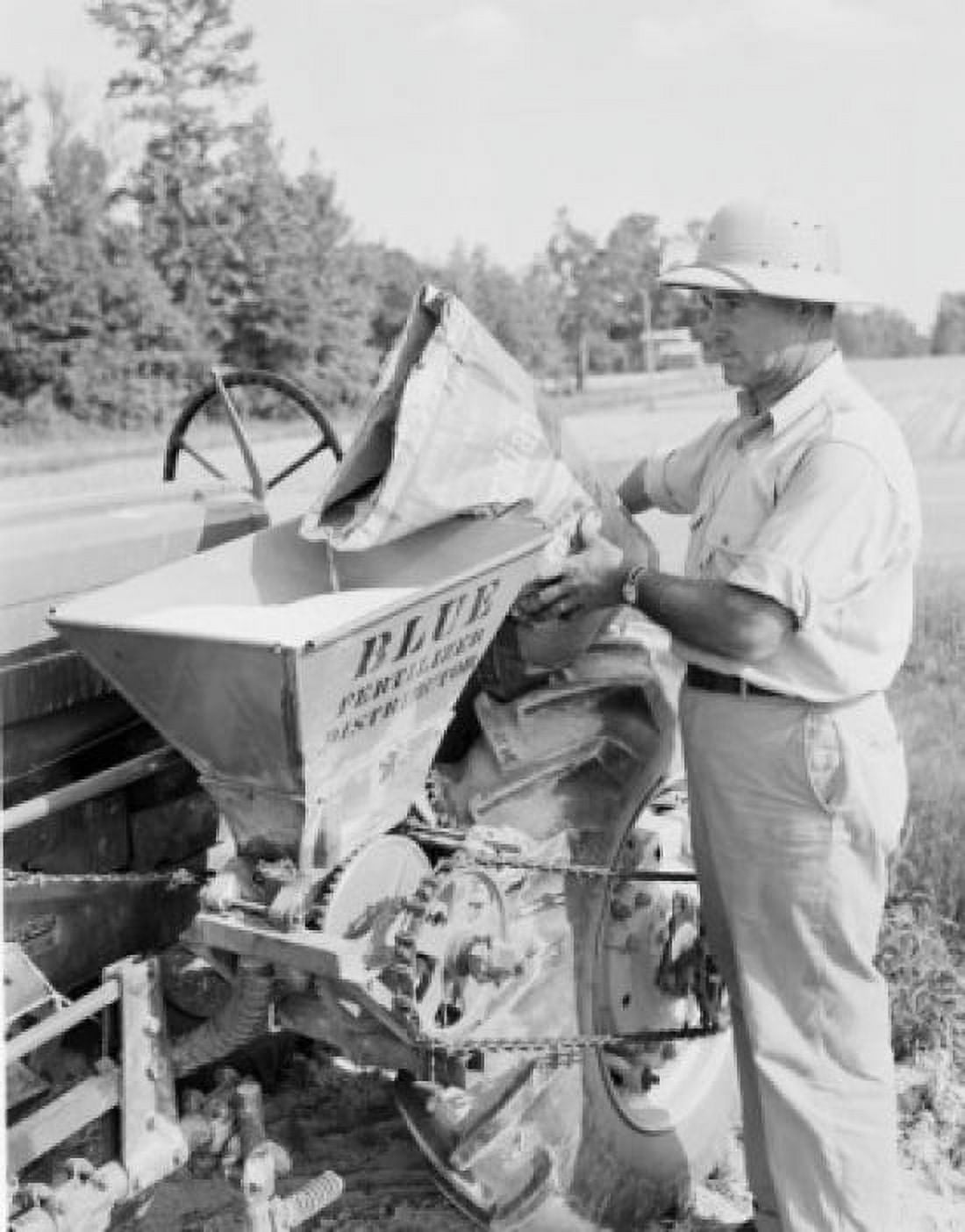Farmer filling fertilizing machine on field Canvas Art - (18 x 24)