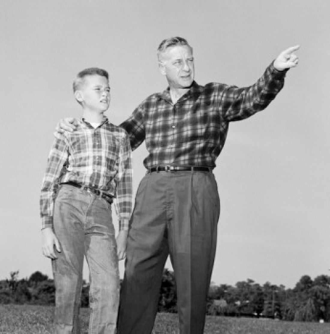 Father and son standing on lawn and looking up Canvas Art - (24 x 36)