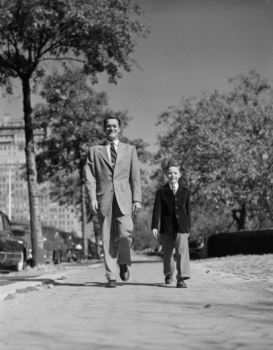 Father and son walking through park Canvas Art - (24 x 36)