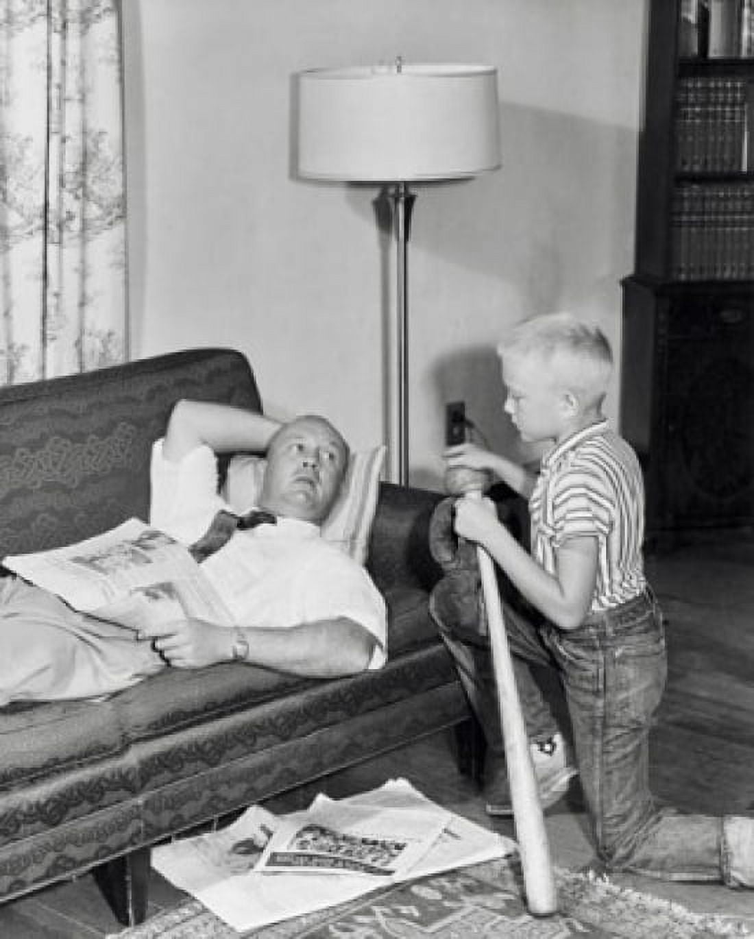 Father lying on a couch with his son kneeling beside him Canvas Art - (24 x 36)